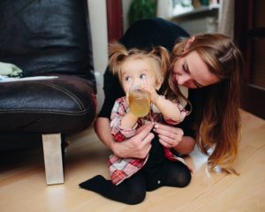 distracted-girl-drinking-a-juice-with-her-mother_1153-1821