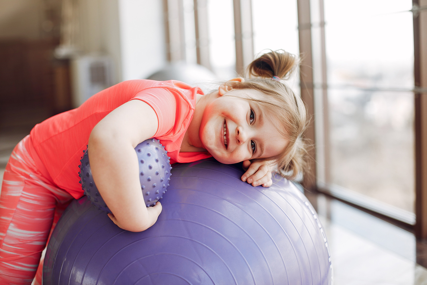 Beautiful girl in the gym. Cute little child in a pink sportswear