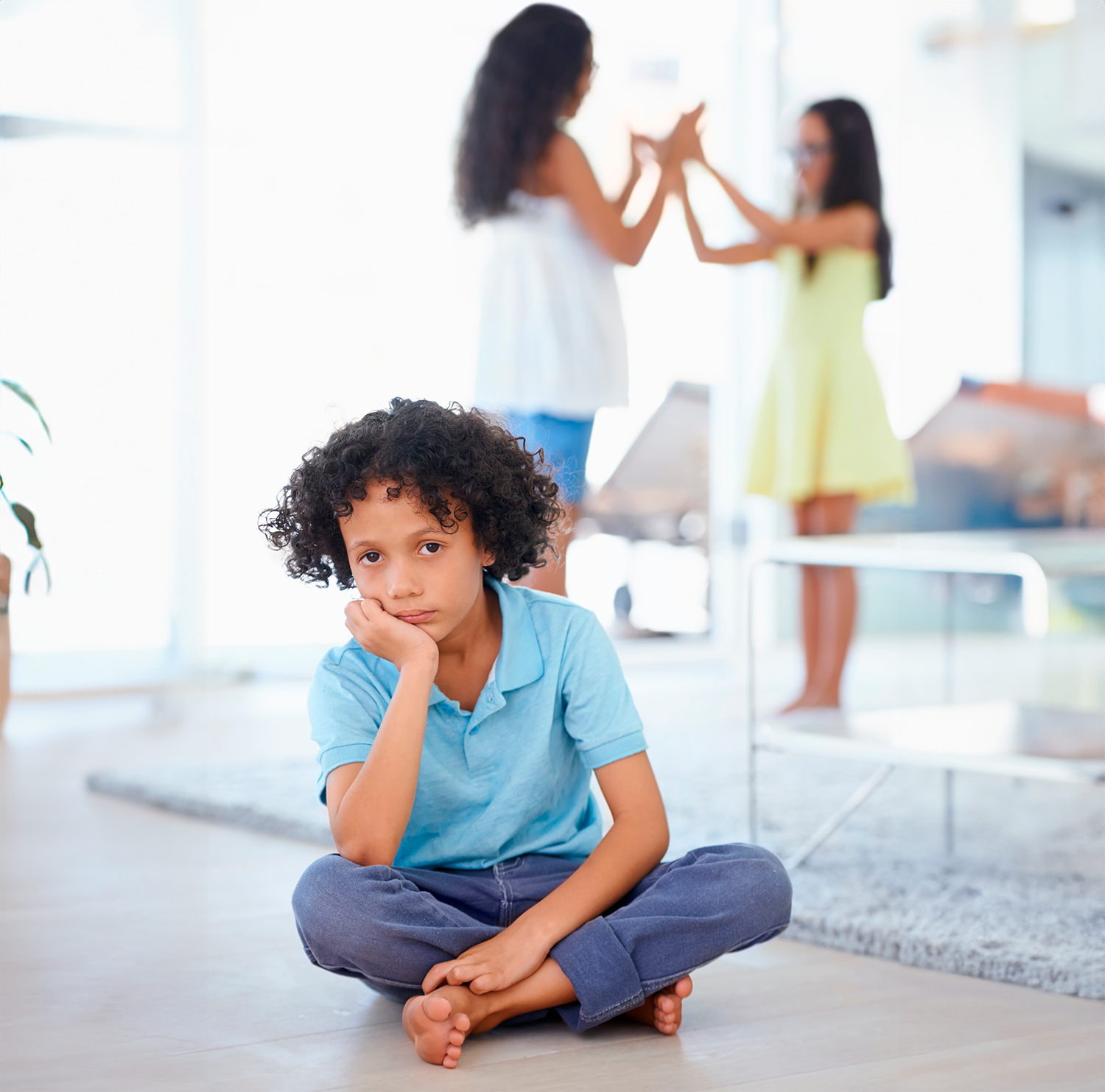 feeling-left-out-portrait-sadlooking-little-boy-sitting-along-with-his-sisters-playing-background