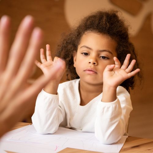 cropped image of educator teaching african american kid numbers in kindergarten